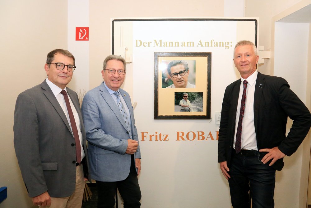 DI Dr. Helmut Herlicska, Obmann Bgm. Ing. Gerhard Zapfl und Mag. Nikolaus Sauer stehen  bei einem Bild von Fritz Robak - dem Vordenker und Pionier der burgenländischen Wasserwirtschaft