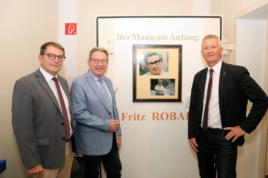 DI Dr. Helmut Herlicska, Obmann Bgm. Ing. Gerhard Zapfl und Mag. Nikolaus Sauer stehen bei einem Bild von Fritz Robak - dem Vordenker und Pionier der burgenländischen Wasserwirtschaft